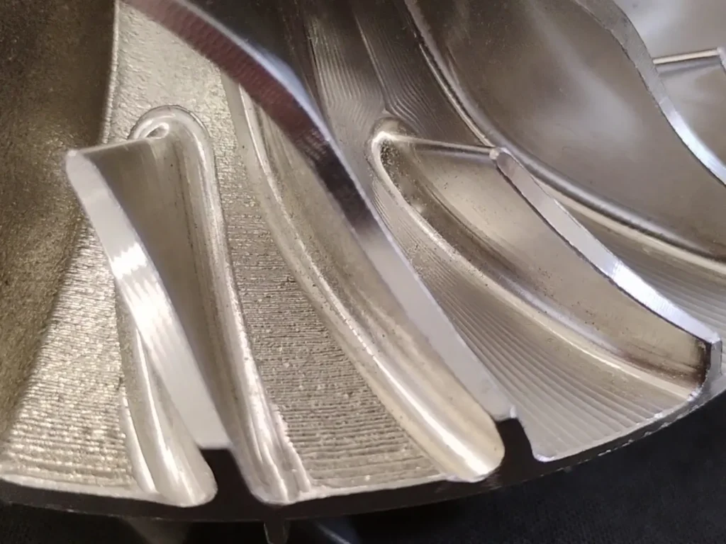 skomplikowana geometria wydruku z metalu i w połowie obrobiona powierzchnia